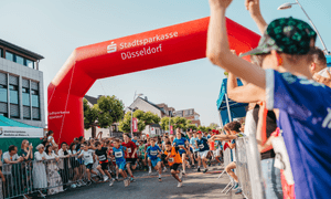 Läufer rennen auf der Zielgerade und werden vom Publikum angefeuert.